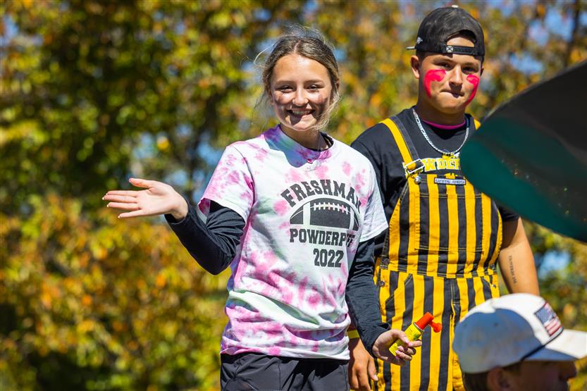 Students ride on a homecoming parade float